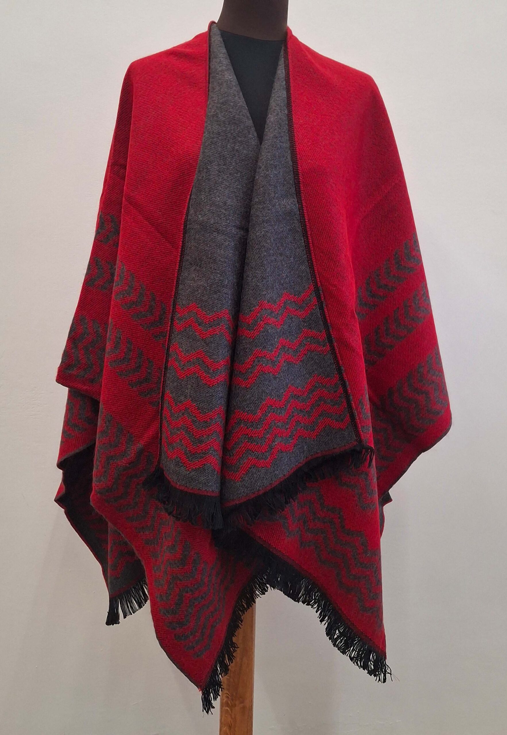 Poncho rouge fabriqué en France avec motifs traditionnels péruviens, offrant confort et style pour toutes les saisons