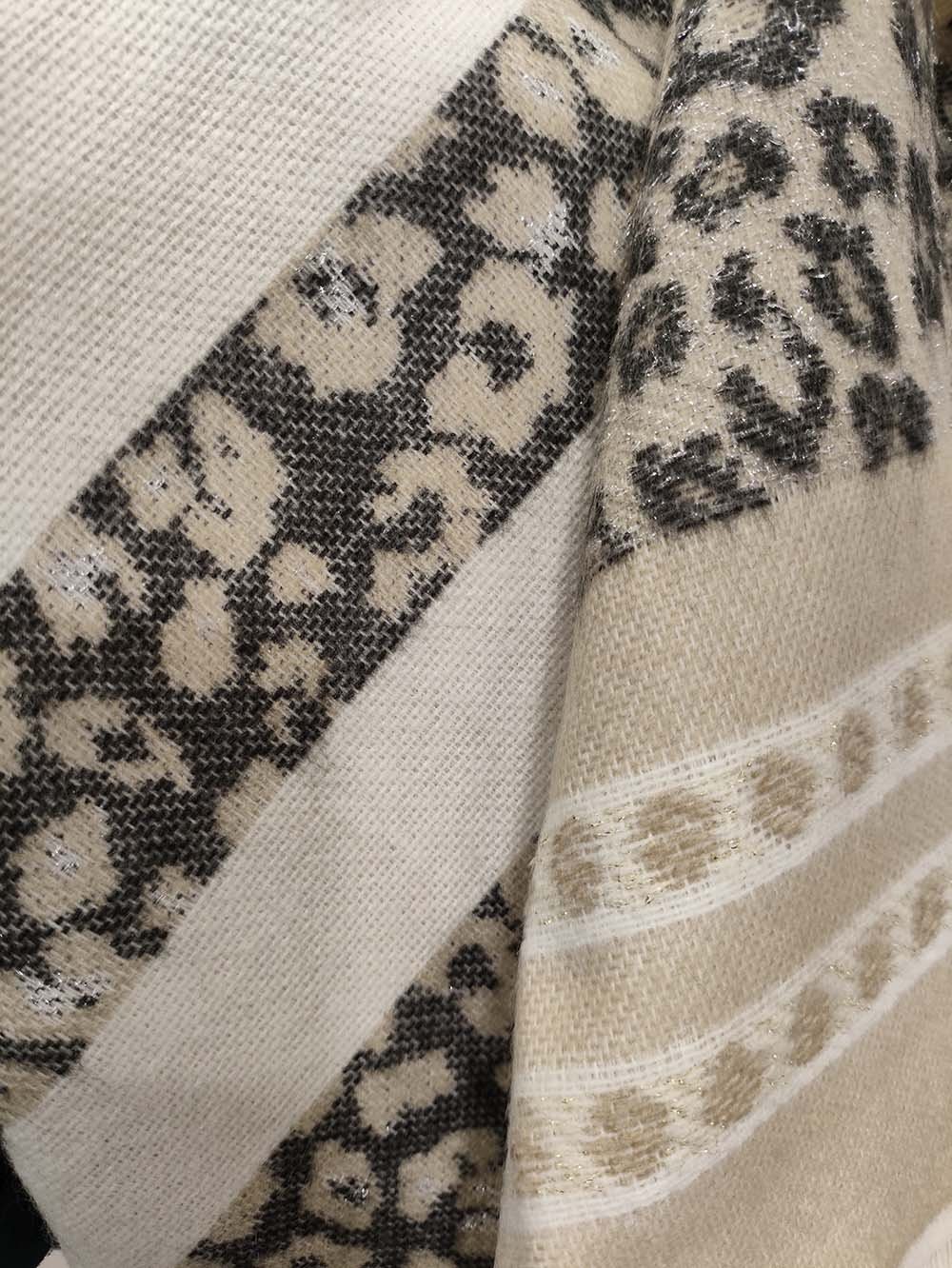 Poncho femme léopard blanc/crème réversible en acrylique, détail de la texture et du motif, porté élégamment sur les épaules, taille unique par acaponcho.fr