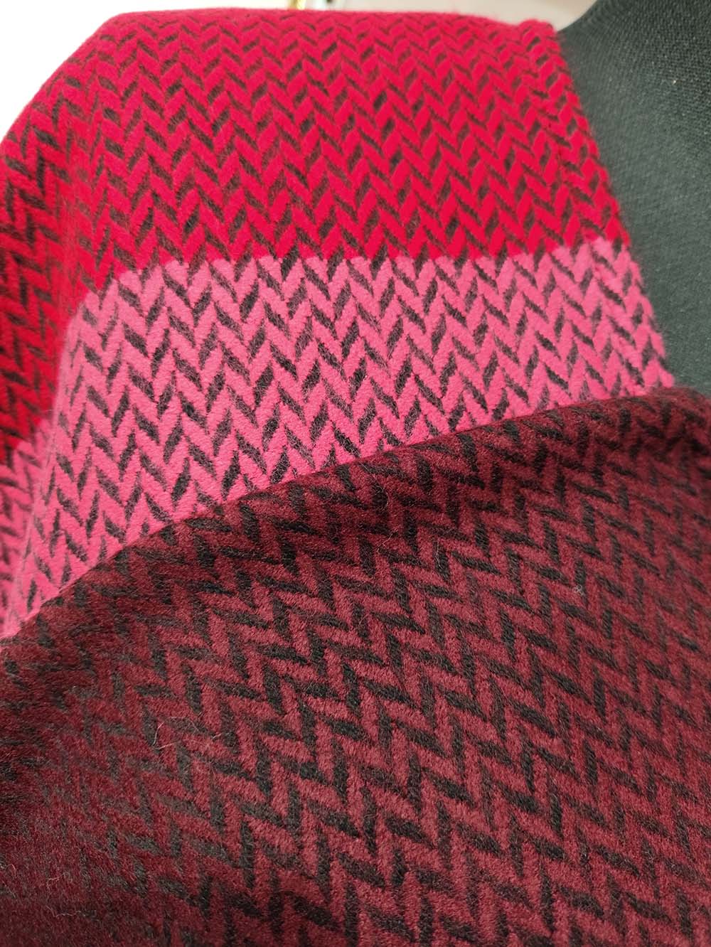 acaponcho.fr vous propose un Poncho rouge tissage latine en acrylique, détail de la texture du tissu, style classique sans capuche, taille unique